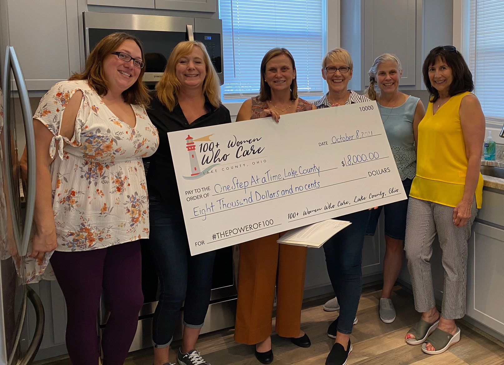 100+ Women Who Care charity receiving check